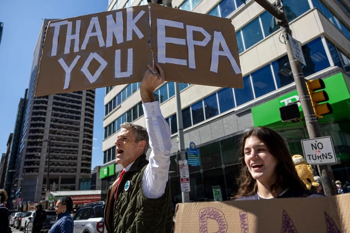 Andrew Kreider, former congressional liaison at EPA's Region 3, holds a sign that says, "Thank you, EPA."