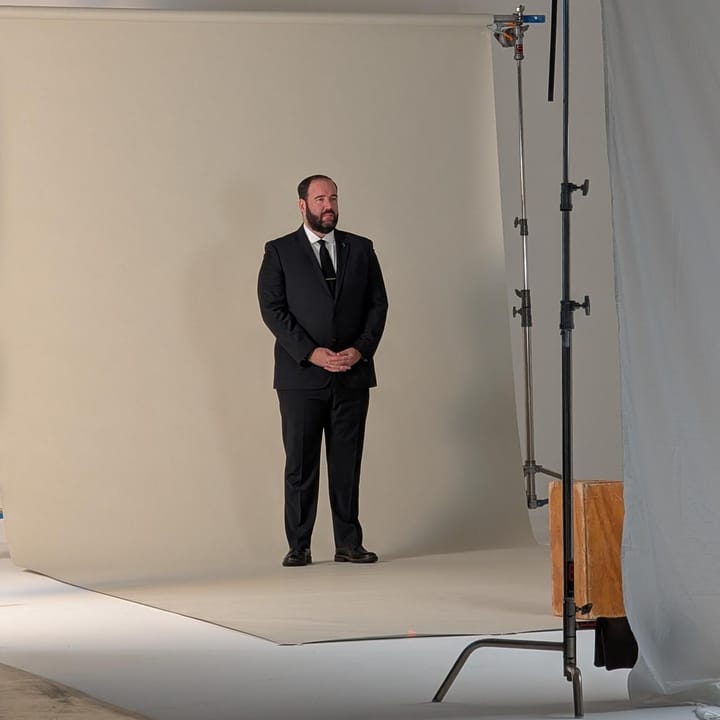 A photo of Philip Fields in wearing a suit standing in a studio.